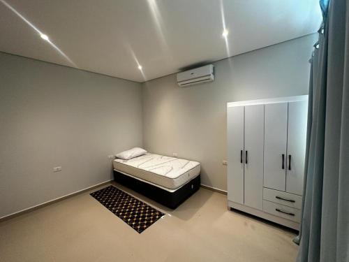 圣贝纳迪诺Puerta del Lago的小房间设有床和橱柜
