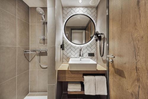 美因茨H2 Hotel Mainz的一间带水槽和镜子的浴室