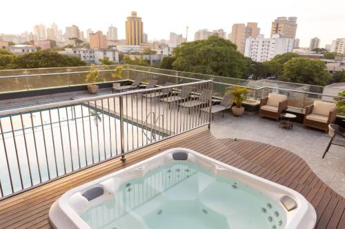 伊瓜苏德尔雷优质酒店的享有城市美景的甲板上的热水浴池