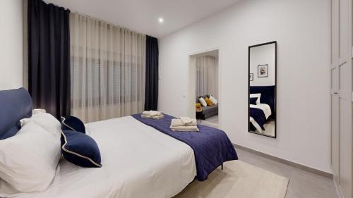 迪德朗日STAY SMART Luxembourg Dudelange Center的一间卧室配有一张带蓝白色枕头的大床