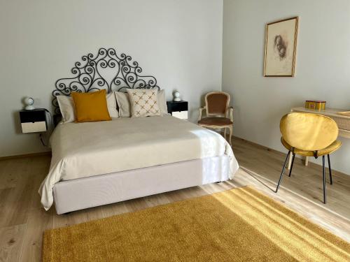 阿尔巴Alba Room 16的一间卧室配有一张大床和一张黄色椅子