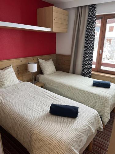 谷雪维尔Ski-in ski-out 1 bed, La Tania的酒店客房设有两张床和窗户。