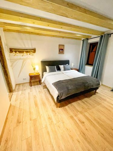埃圭斯海姆Chambre Super Broussard的一间卧室设有一张大床,铺有木地板