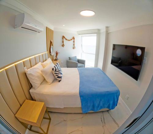 累西腓Flat Radisson Recife的一间卧室配有一张大床和电视