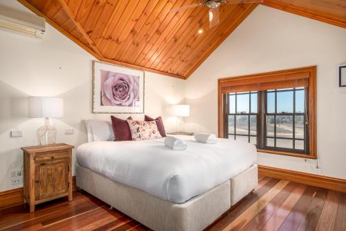 波高尔宾Bonvilla Estate的一间卧室设有一张大床和木制天花板