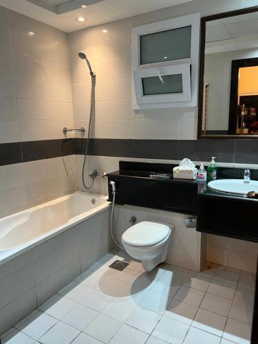 迪拜Sky Inn Hostel For Males的浴室配有卫生间、盥洗盆和浴缸。