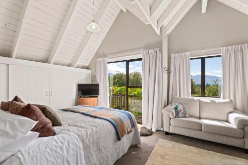皇后镇山景度假屋的一间卧室配有一张床、一张沙发和窗户。