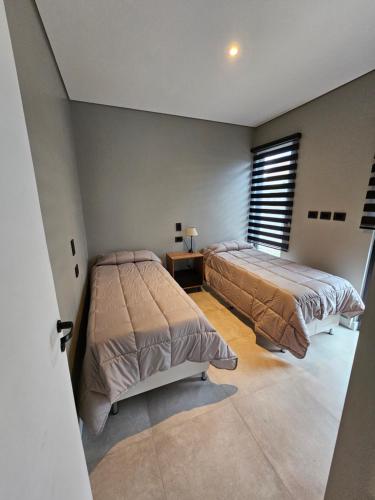 乌斯怀亚Andino House的一间卧室设有两张床、一张桌子和一个窗口