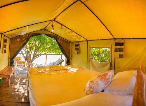 佩德纳莱斯Glamping EcoLodge Cueva De Las Aguilas的大型黄色帐篷,配有两张床