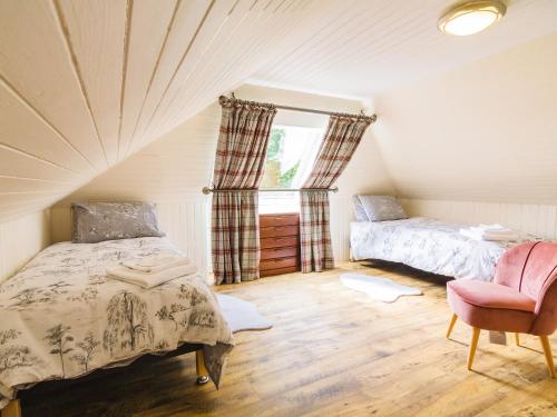 CrayKeepers Cottage - Uk30246的卧室配有床、椅子和窗户。