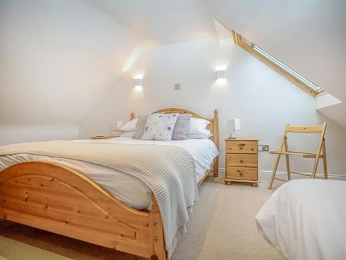 AllantonPurves Cottage的一间卧室配有一张木床和一把椅子