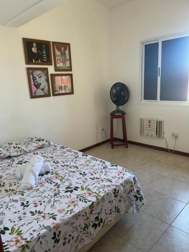 卡马萨里O Paraíso é aqui: Pé na Areia em Arembepe的一间卧室配有一张带花卉棉被的床
