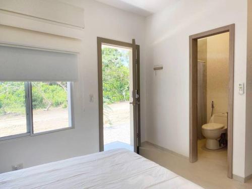 圣埃莱纳Estudio 1, Las Castañas的一间卧室设有一张床、一个卫生间和一个窗口
