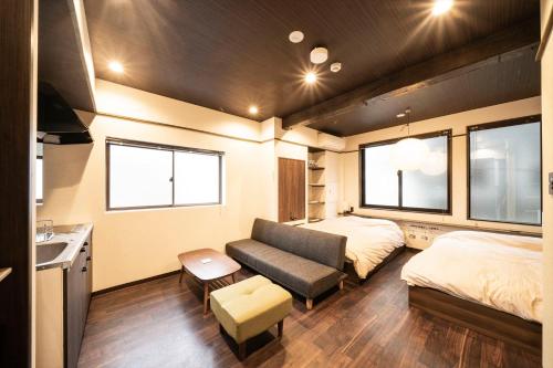 神户かゑる屋的一间设有两张床和一张沙发的房间