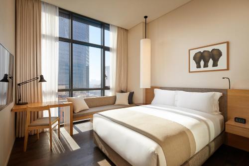 首尔Shilla Stay Samsung COEX Center的一间卧室配有一张床、一张桌子和一张沙发