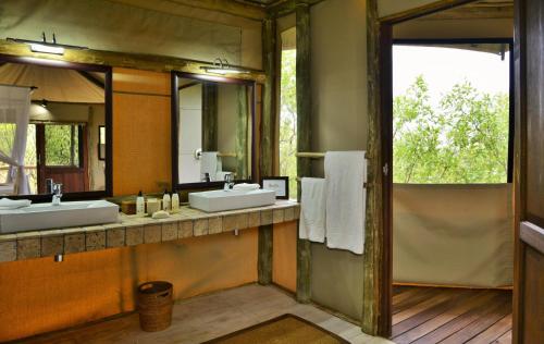 SavutiGhoha Hills Savuti Lodge的一间带两个盥洗盆和大镜子的浴室