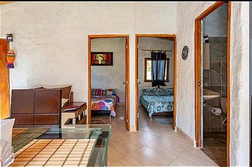 麦德林alto palmas 2.0的一间带玻璃桌的客厅和一间卧室