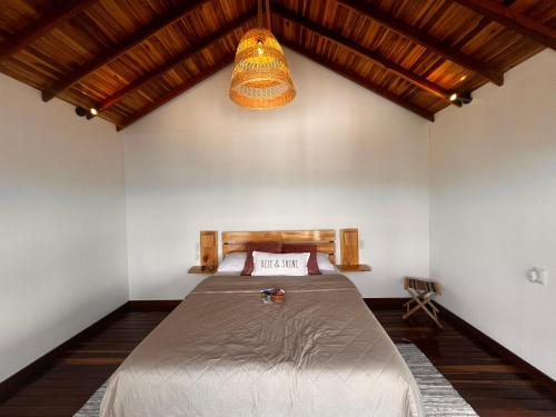 库里蒂Chalets La Zima - Jaya的一间卧室配有一张床和吊灯