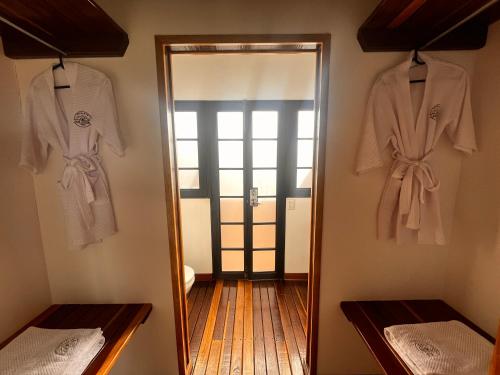 库里蒂Chalets La Zima - Jaya的一间房间,墙上挂着两件衬衫,还有一面镜子