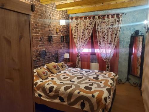 布里奥内斯Chalet entero en La Rioja的一间卧室设有一张床和砖墙