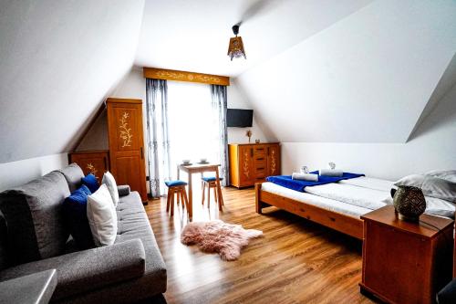 苏凯Apartamenty u Trebuniów的一间卧室配有一张床、一张沙发和一张桌子