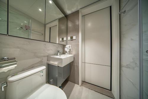 深圳铂瑞斯行政公寓(深圳海岸城南油服装城店)的浴室配有卫生间、盥洗盆和淋浴。