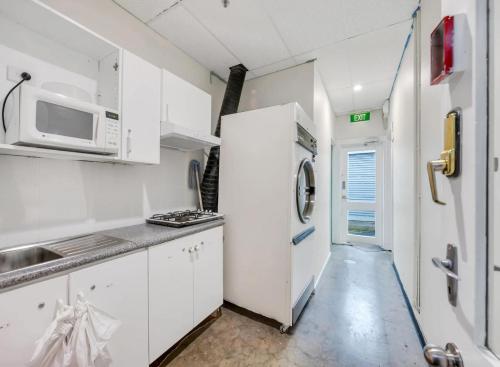 阿德莱德Studio 26 - Wright Lodge的白色的厨房配备了微波炉和冰箱。