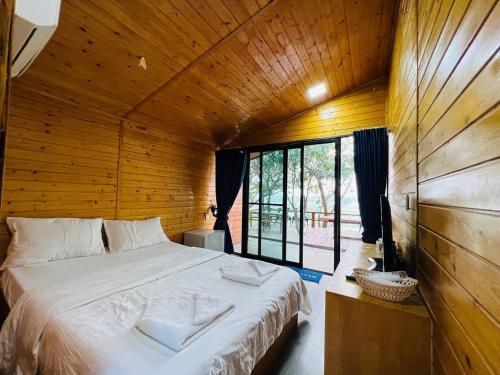 Chomka Thnong Resort的木制客房内的一间卧室配有一张大床