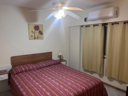 布兰卡港Apartamento Pacífico Downtown Inn的一间卧室配有一张床和吊扇