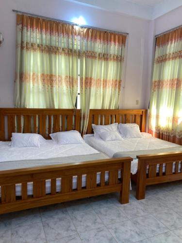 波来古市Homestay 484的卧室设有两张单人床和窗帘