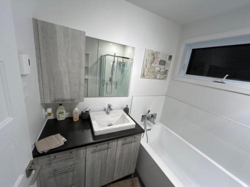 隆格伊Unactivated的浴室配有盥洗盆、镜子和浴缸