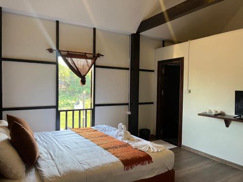 琅勃拉邦Villa Namkhan Heritage的一间卧室设有一张床和一个大窗户
