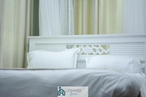 内罗毕Ushindi Bronx Villas的白色的床头板和镜子