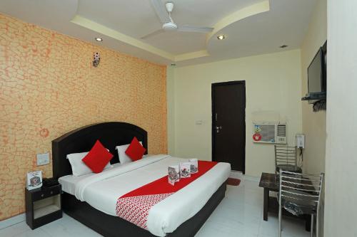 哈里瓦Flagship Hotel Neel Ganga的一间卧室配有一张带红色枕头的大床