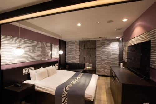 松户市HOTEL KSEA (Adult Only)的一间卧室配有一张大床和电视