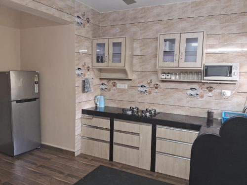 瓦尔恰Coconut Grove Holiday Apartment的厨房配有柜台和冰箱。