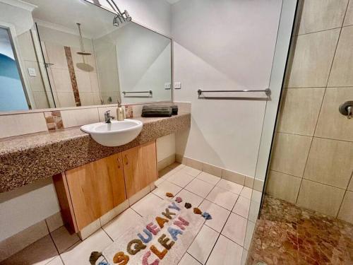 UtakarraThe Wildflower- Luxury Home Stay的一间带水槽、镜子和淋浴的浴室
