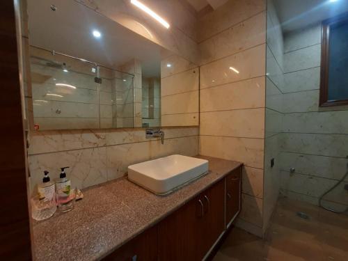 古尔冈Nearmi Hotels Banquets Medanta IKEA Sector 47 - Gurugram的一间带水槽和玻璃淋浴的浴室