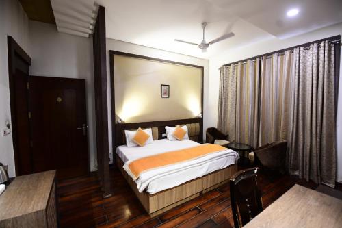 菩提伽耶Hotel Jataka Inn的酒店客房带一张床、一张桌子和椅子