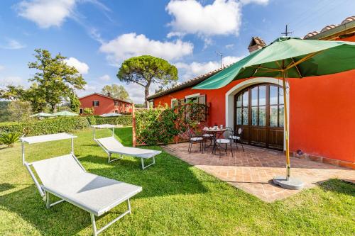 卡斯泰尔菲奥伦蒂诺Agriturismo Maramaldo - Happy Rentals的庭院里一座带椅子和遮阳伞的橙色房子