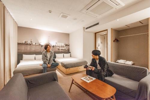 北九州Hotel Relief Kokura Annex的两人坐在酒店房间