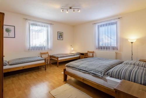 利普托斯基米库拉斯Pension Iveta的一间卧室设有两张床和两把椅子,窗户