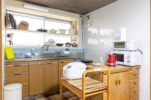 长崎アルマス伊王島的厨房配有带烤面包机和微波炉的柜台。