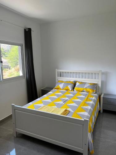 ÓrgãosVILLA NAYELI Luxury and Simplicity的一间卧室配有一张带黄白色床单的床和窗户。
