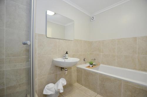 开普敦Apartment in Century City的浴室配有盥洗盆和浴缸。
