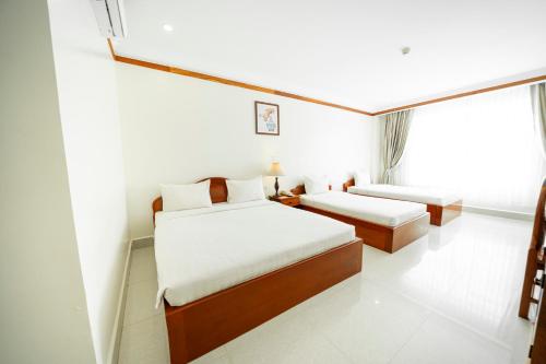 PursatPursat Riverside Hotel & Spa的酒店客房设有两张床和窗户。