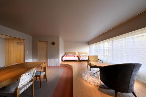 七尾ROOM design hotel的一间带餐桌的客厅和一间卧室