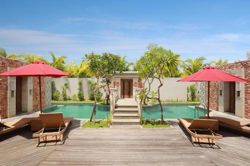 金巴兰Vivara Bali Private Pool Villas & Spa Retreat的一个带游泳池和红伞的度假村