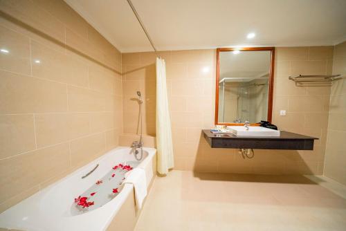 PursatPursat Riverside Hotel & Spa的带浴缸和盥洗盆的浴室