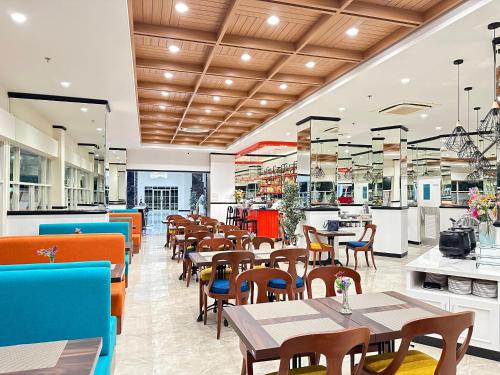 泗水d'primahotel Jemursari Surabaya的一间带桌椅的餐厅和一间自助餐厅